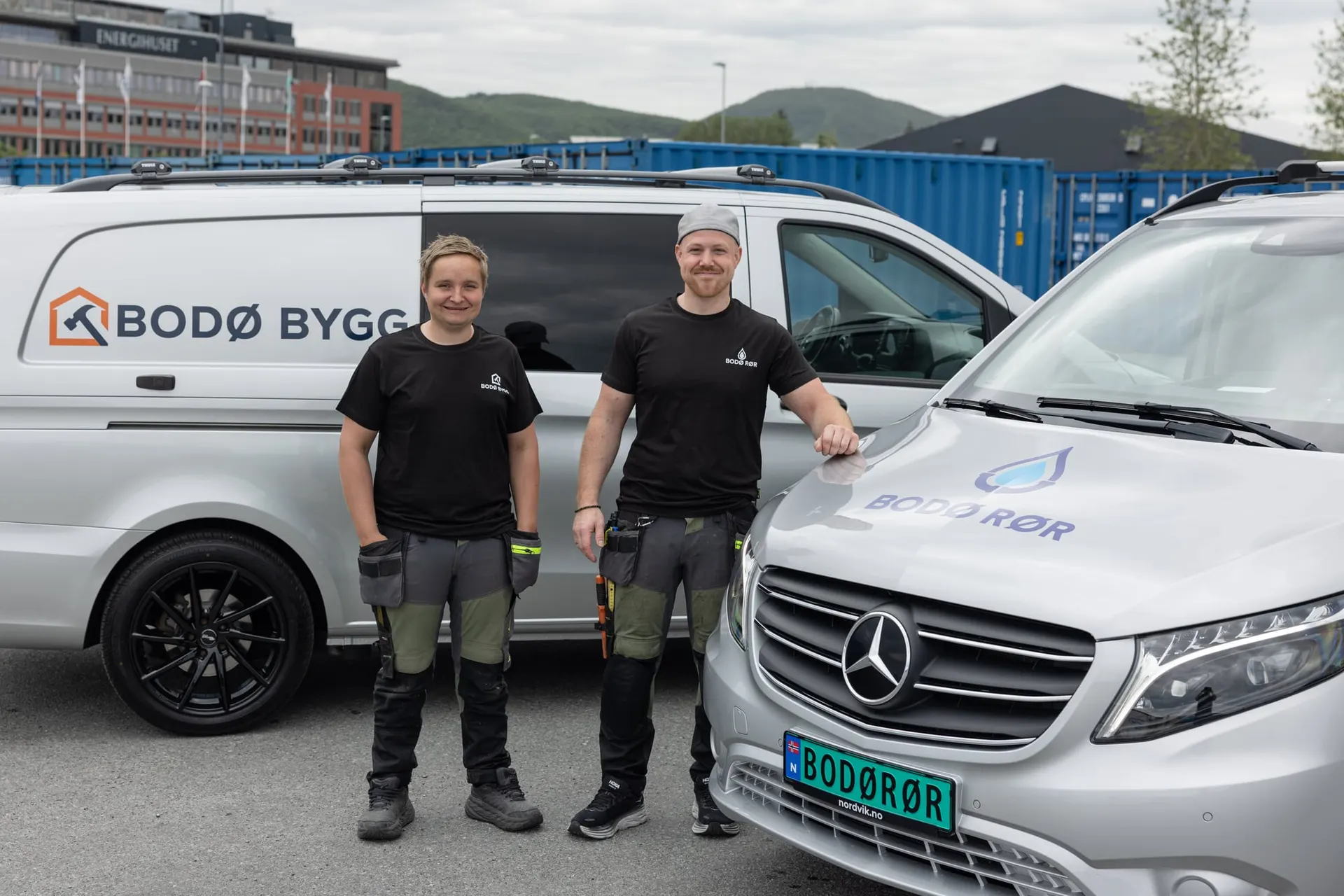 Bodø Rør og Bodø Bygg sammen foran firmabilene sine.